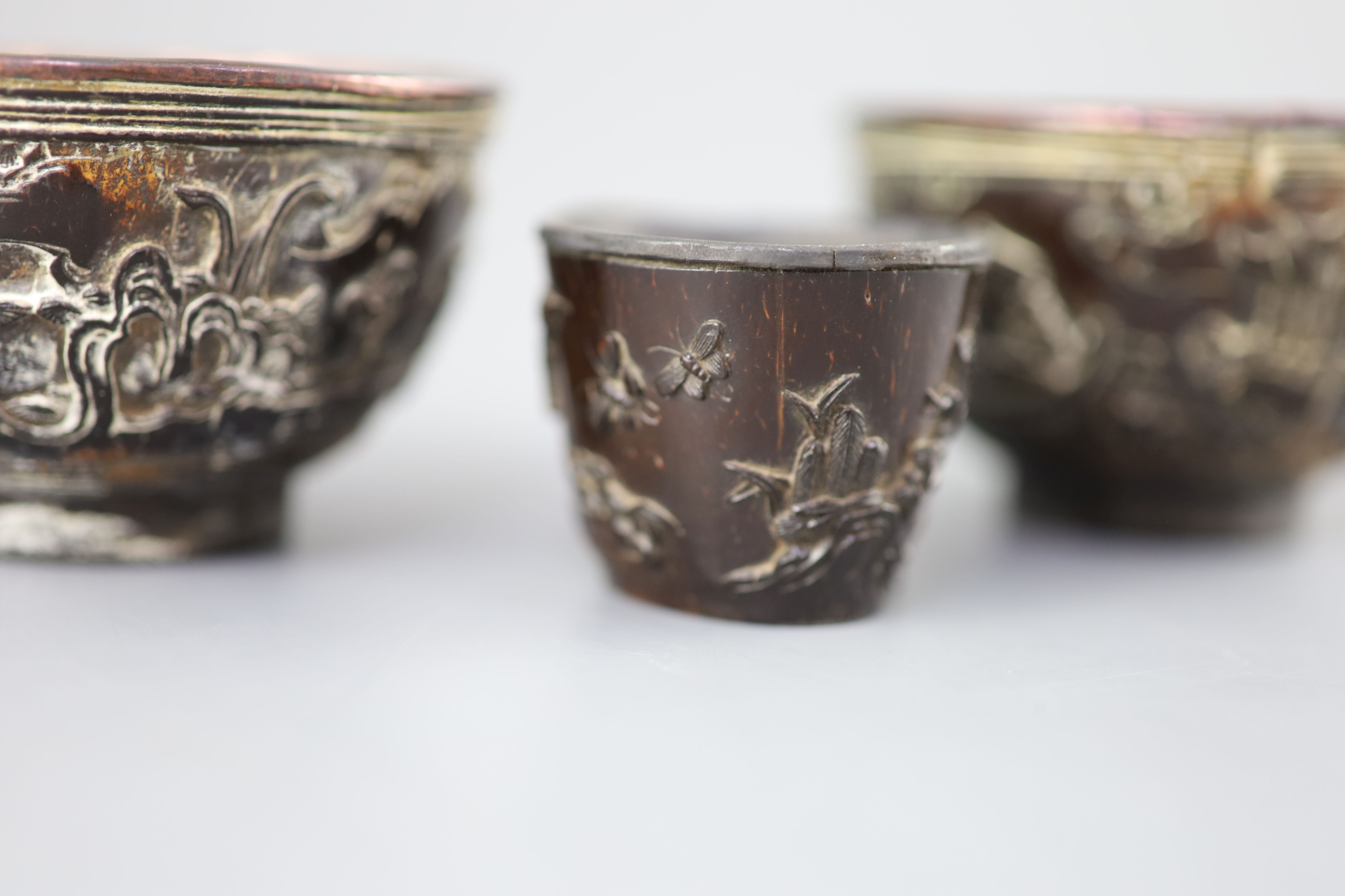 A pair of Chinese coconut landscape cups and a similar peach-shaped cup, 18th/19th century,